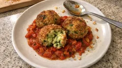 Knusprige Zucchinibällchen auf tomatig-würzigem Paprika-Gemüse – so werden sie richtig saftig